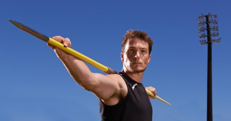 Athlete in throwing stance practicing spear throw technique outdoors