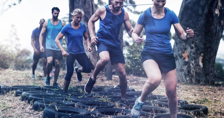 Group of athletes training together on an obstacle course with tires