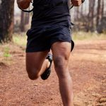 Endurance athlete running through forest trail, illustrating fat adaptation training for OCR
