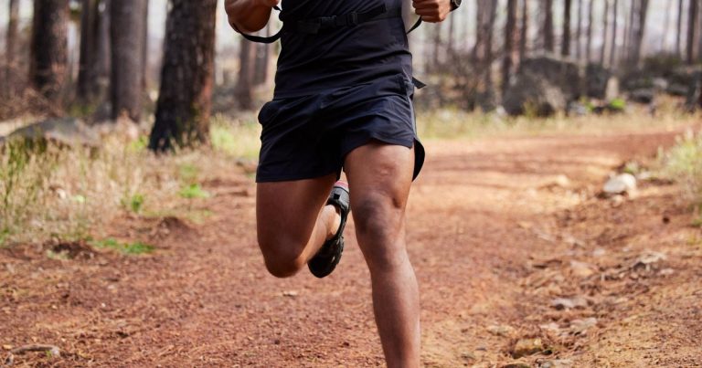 Endurance athlete running through forest trail, illustrating fat adaptation training for OCR
