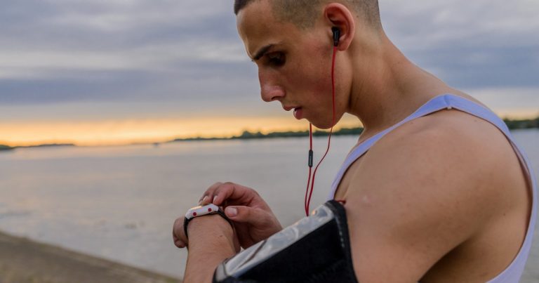 Runner checking a GPS smartwatch on their wrist during an outdoor training session