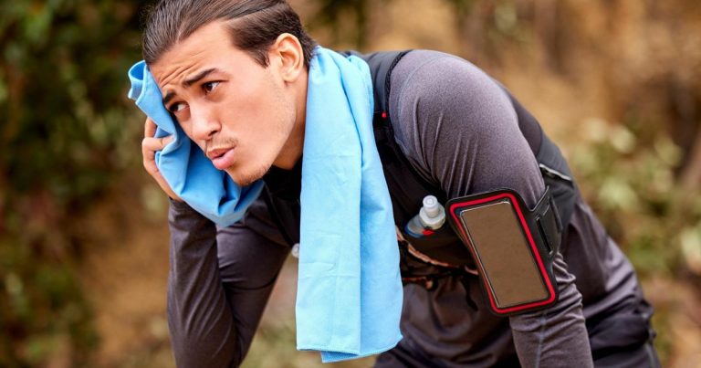 Exhausted trail runner catching breath in the woods