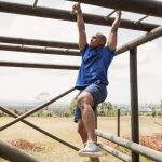 Athlete climbing monkey bars on an obstacle course