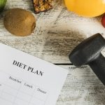 Diet plan with vegetables and dumbbells representing athlete nutritional periodization