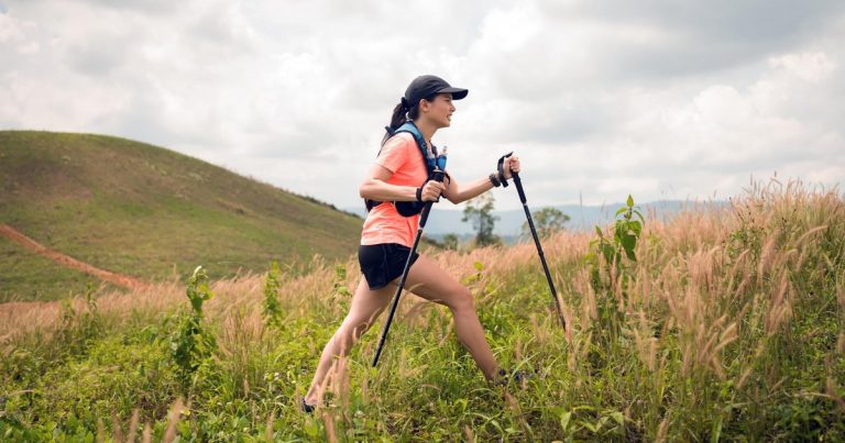 Trail runner using trekking poles on mountain terrain