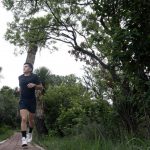 Trail runner on a dirt path through natural terrain