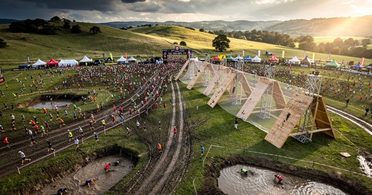 Aerial view of large-scale obstacle course racing event with athletes on expansive course layout