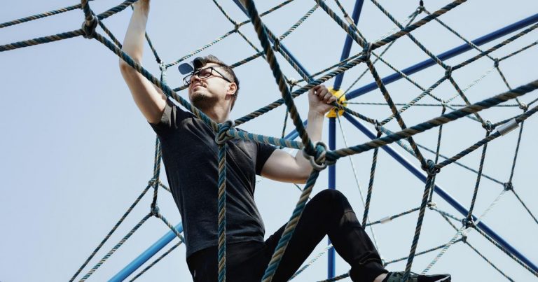 OCR athlete climbing cargo net obstacle on race course