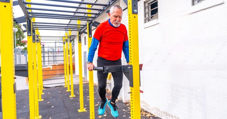 Senior male athlete doing pull-ups on outdoor fitness equipment — Masters OCR competitor