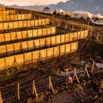 Aerial view of an OCR event venue with obstacles and safety infrastructure at golden hour