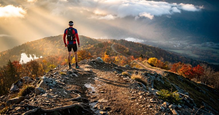 OCR athlete standing at the summit of a mountain trail surveying the course ahead